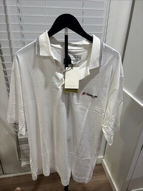 Cutter&Buck  White Polo with Navy Stripe Collar and Red Travelers Logo.
